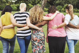 women walking arm in arm for support